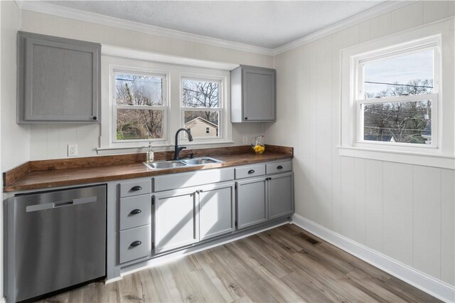 kitchen with gray cabinetry, dishwasher, a sink, and wooden counters