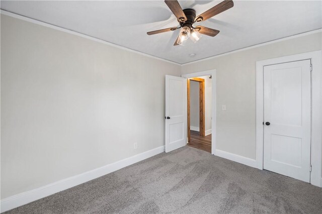 unfurnished bedroom with ceiling fan, baseboards, crown molding, and light colored carpet