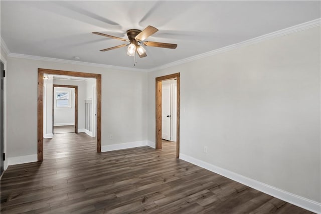 spare room featuring dark wood-style floors, ornamental molding, a ceiling fan, and baseboards