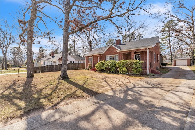 view of front facade with a garage, a chimney, fence, an outdoor structure, and brick siding