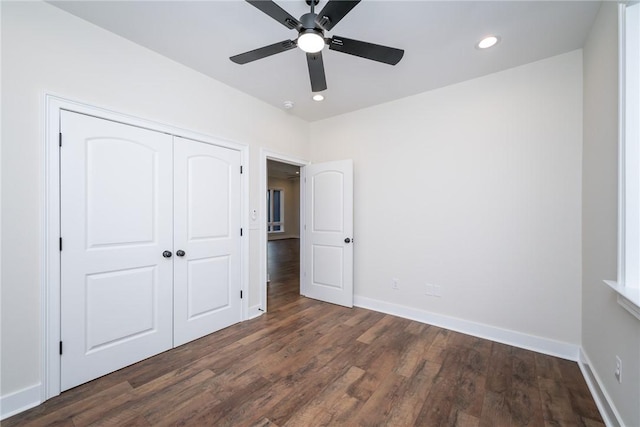 unfurnished bedroom featuring baseboards, dark wood finished floors, a closet, and recessed lighting