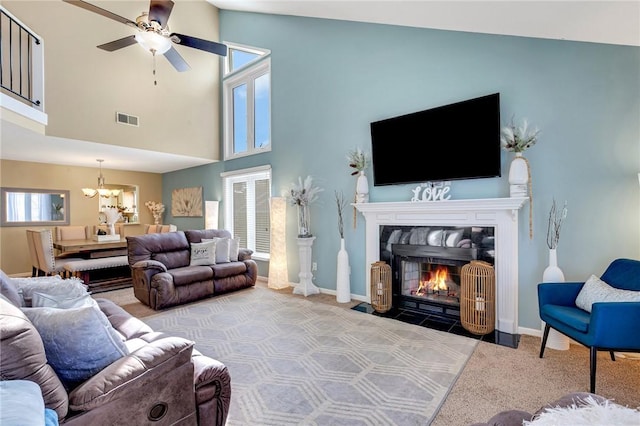 living room featuring plenty of natural light, visible vents, a fireplace with flush hearth, and light colored carpet