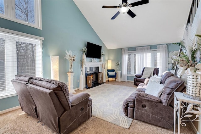 living room with light carpet, a fireplace with flush hearth, a ceiling fan, and baseboards