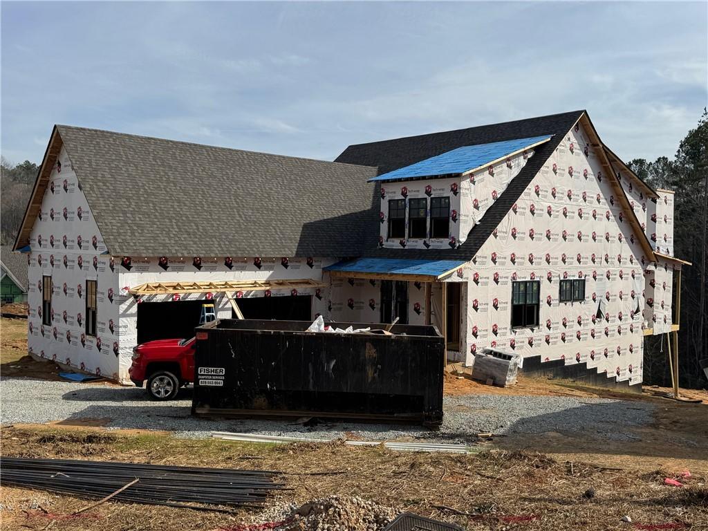 unfinished property with a shingled roof