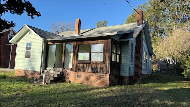 view of front of property featuring entry steps, crawl space, a chimney, and a front yard