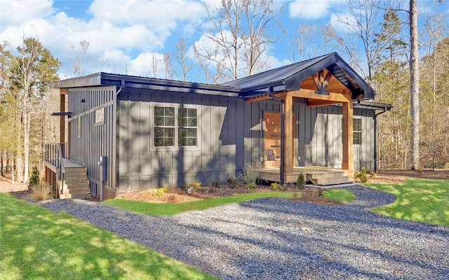 view of front facade with board and batten siding and a front yard