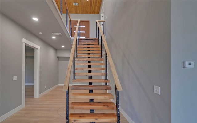 stairway with baseboards, visible vents, wood finished floors, and recessed lighting