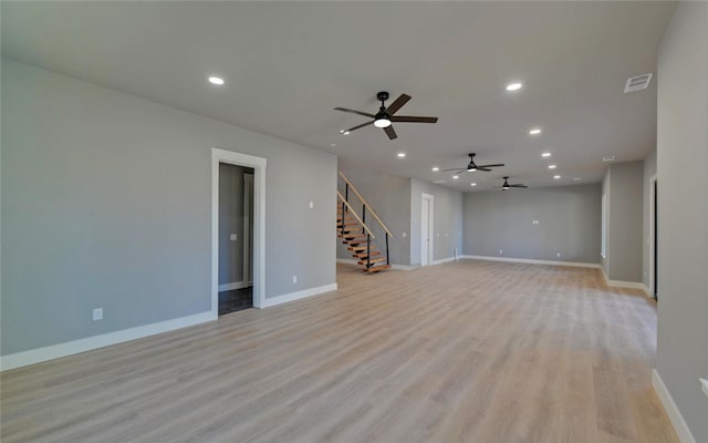 empty room with light wood-type flooring, recessed lighting, baseboards, and stairs