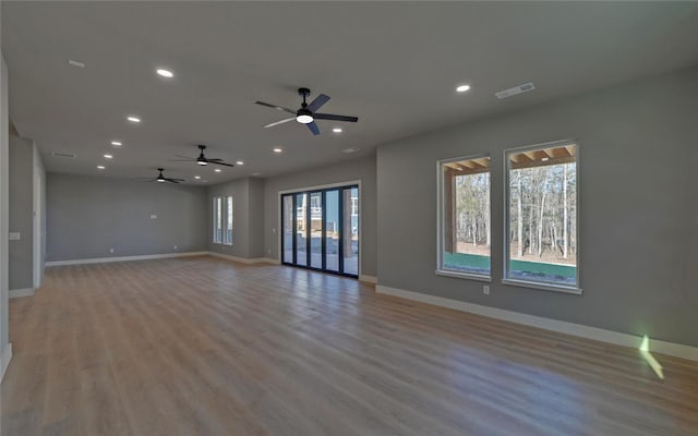 empty room featuring recessed lighting, baseboards, and light wood finished floors