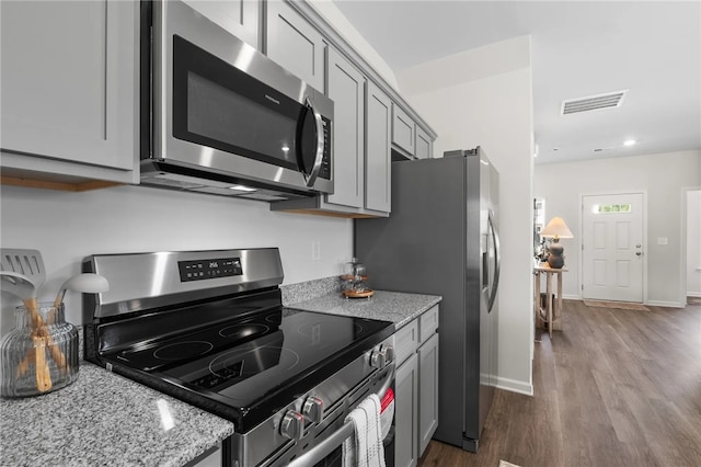 kitchen with visible vents, appliances with stainless steel finishes, light stone counters, and gray cabinetry