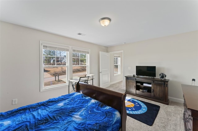 bedroom featuring baseboards, visible vents, and light colored carpet