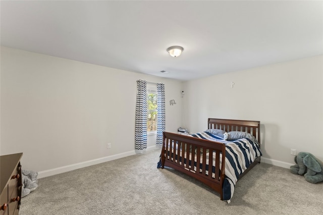 bedroom featuring light carpet and baseboards