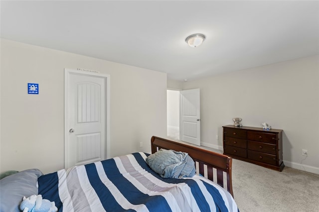 bedroom with baseboards and light colored carpet