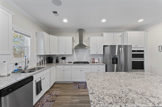 kitchen with white cabinets, wall chimney exhaust hood, light stone countertops, stainless steel appliances, and a sink