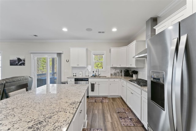 kitchen featuring visible vents, white cabinets, light stone counters, stainless steel appliances, and a sink