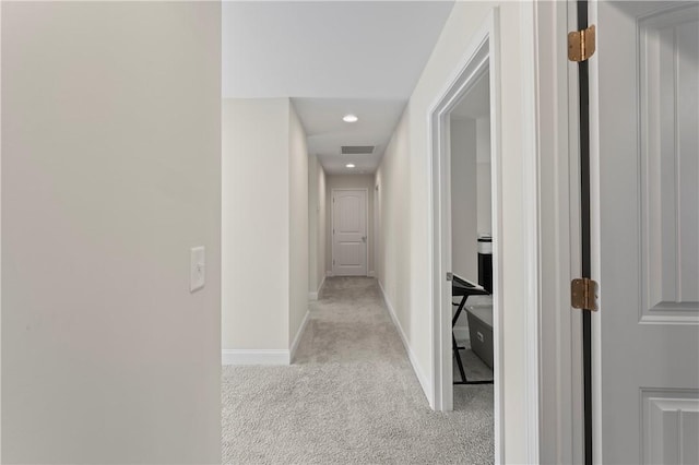 hallway with light carpet, recessed lighting, visible vents, and baseboards