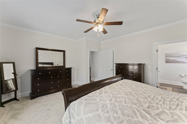 bedroom featuring light carpet, ornamental molding, ensuite bathroom, and baseboards