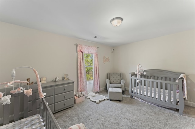 bedroom with light carpet, a nursery area, visible vents, and baseboards