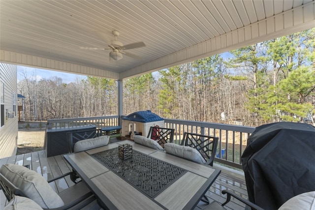 wooden deck featuring outdoor dining area, a grill, and a ceiling fan