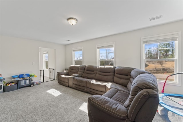 living area featuring visible vents, plenty of natural light, and carpet flooring