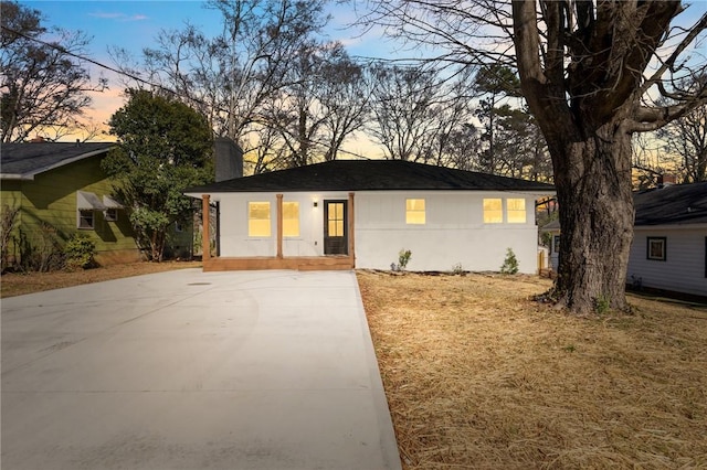 single story home with a chimney and stucco siding