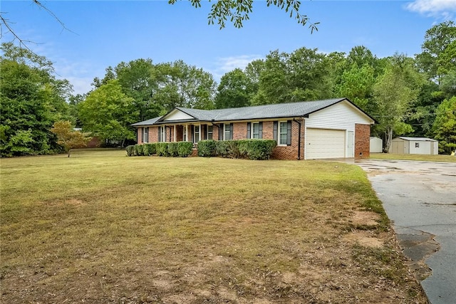 ranch-style home featuring driveway, an attached garage, a shed, a front lawn, and brick siding