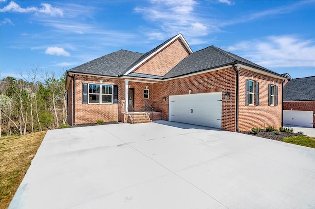 view of front facade with a garage, concrete driveway, brick siding, and roof with shingles