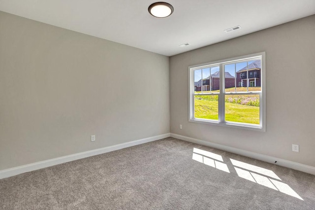 unfurnished room with visible vents, light carpet, and baseboards