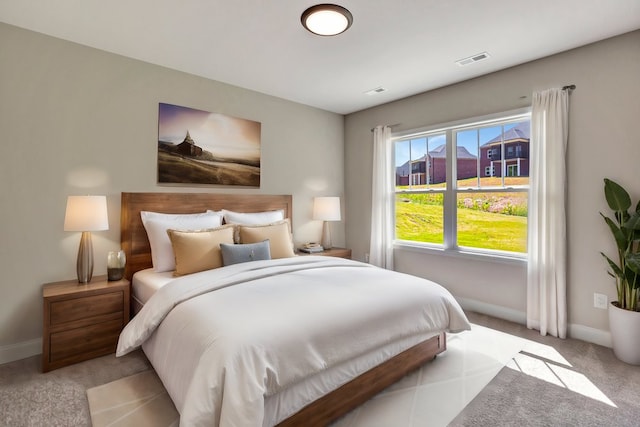 bedroom featuring light carpet, visible vents, and baseboards