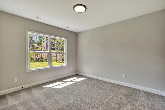 unfurnished room with baseboards, visible vents, and carpet flooring