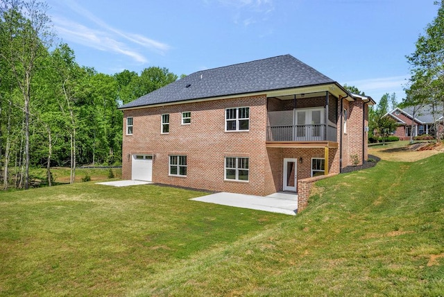 back of house with a patio, a garage, brick siding, a yard, and driveway