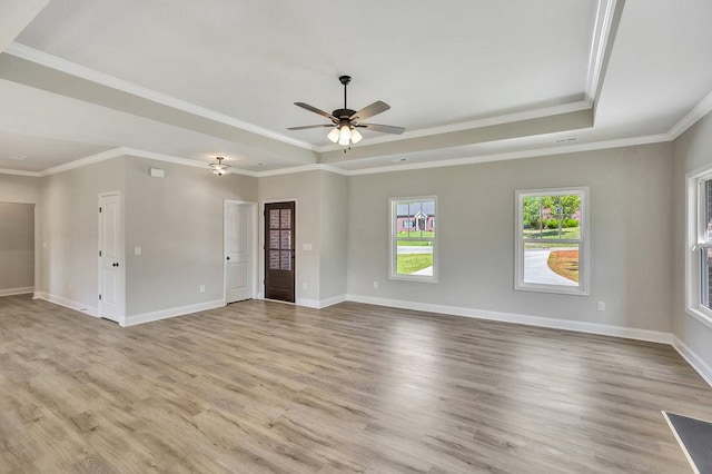 unfurnished room featuring a tray ceiling, light wood-style floors, ornamental molding, ceiling fan, and baseboards