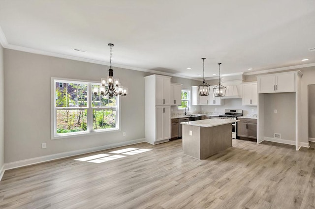 kitchen featuring stainless steel stove, white cabinetry, pendant lighting, and a center island