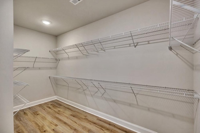 walk in closet featuring visible vents and wood finished floors