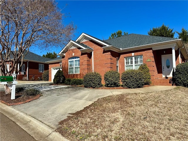 single story home featuring a shingled roof, brick siding, driveway, and an attached garage