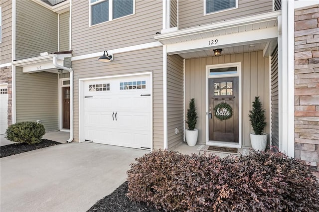 entrance to property featuring driveway and an attached garage