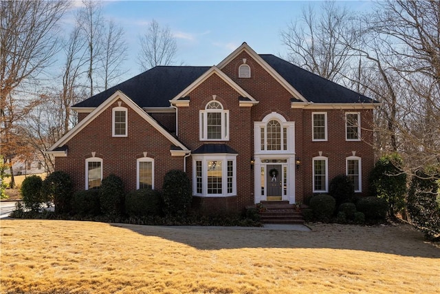 view of front of property featuring a front yard and brick siding