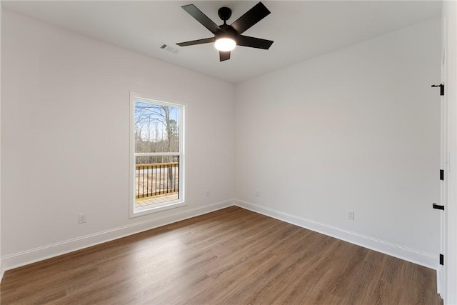 empty room featuring visible vents, ceiling fan, baseboards, and wood finished floors