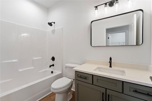 bathroom featuring toilet, washtub / shower combination, wood finished floors, and vanity