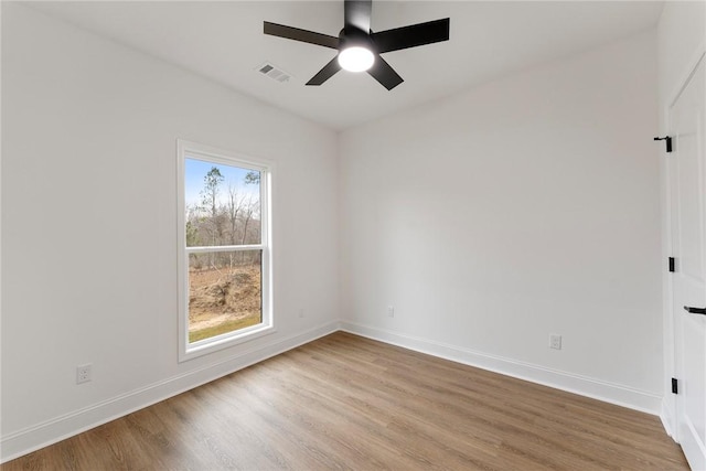 empty room featuring light wood-style floors, visible vents, ceiling fan, and baseboards