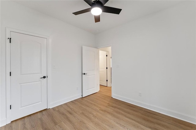 unfurnished bedroom featuring light wood finished floors, a ceiling fan, and baseboards