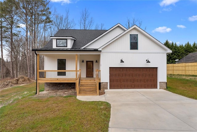 modern inspired farmhouse with roof with shingles, covered porch, concrete driveway, a front yard, and fence