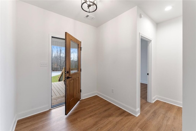 entrance foyer with light wood-style floors, visible vents, and baseboards