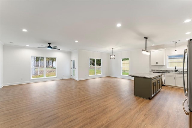 kitchen featuring a kitchen island, white cabinetry, light wood-style floors, open floor plan, and decorative light fixtures