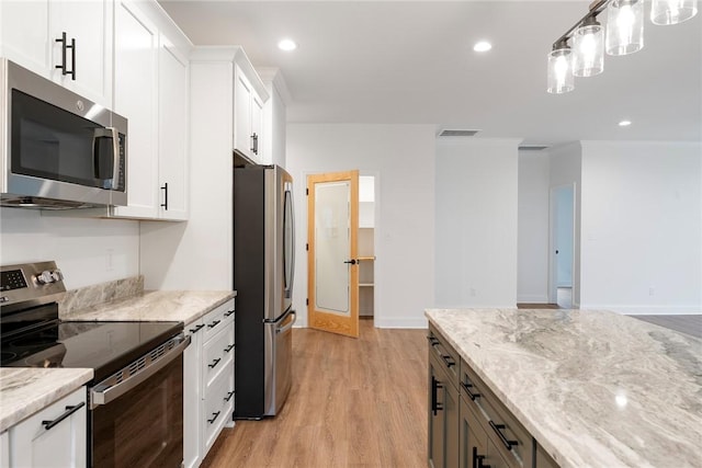 kitchen with light stone counters, appliances with stainless steel finishes, and white cabinetry