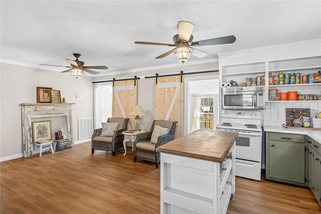 93 Parnell Rd, Abbeville, SC 29620 - kitchen with stainless steel microwave, white range with electric cooktop, a barn door, ceiling fan, and crown molding