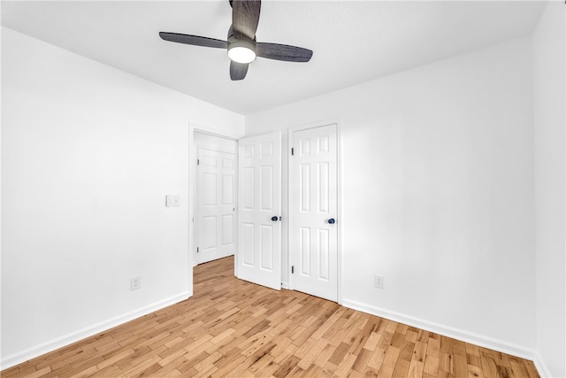 unfurnished bedroom with ceiling fan, a closet, light wood-type flooring, and baseboards