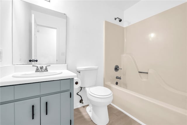 bathroom featuring bathtub / shower combination, vanity, toilet, and wood finished floors