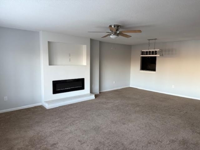 202 Northlake Dr, Anderson, SC 29621 - unfurnished living room featuring a ceiling fan, a glass covered fireplace, dark carpet, and baseboards