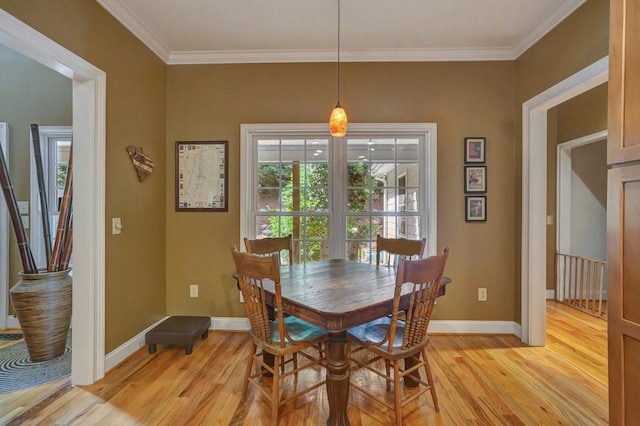 dining room with light wood-style flooring, baseboards, and crown molding